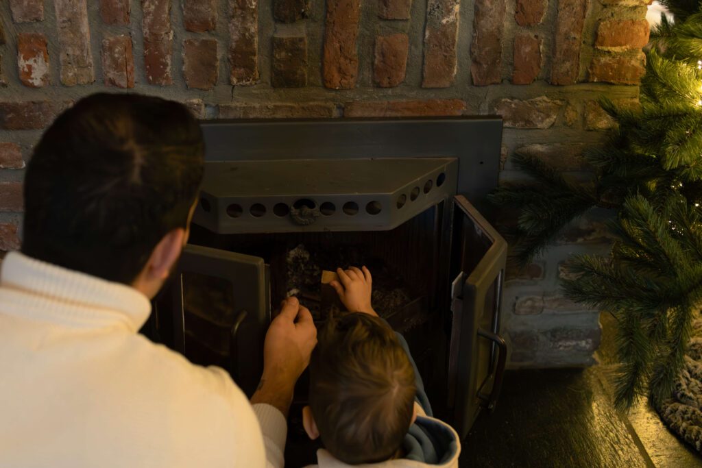 Vader en zoon steken samen de haard aan